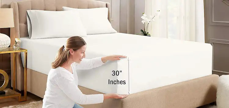 Woman holding a 30-inch mattress topper in a bedroom setting.
