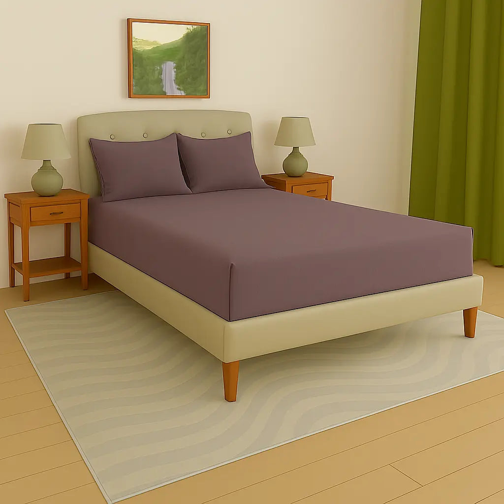 Bedroom with a bed featuring purple bedding, two nightstands with lamps, and a painting on the wall at- EgyptianHomeLinens.com