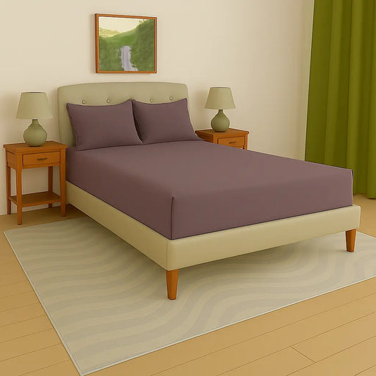 Bedroom with a bed featuring purple bedding, two nightstands with lamps, and a painting on the wall at- EgyptianHomeLinens.com